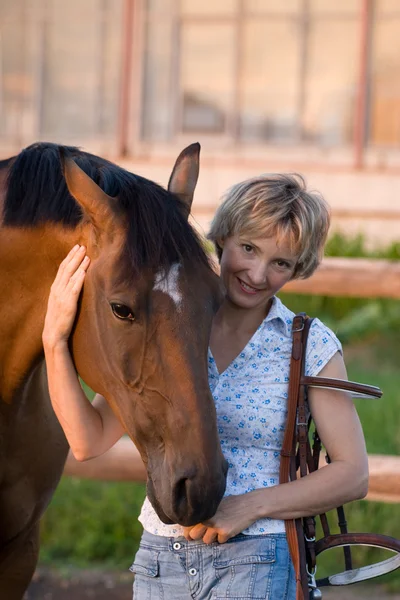 Frau umarmt braunes Pferd — Stockfoto