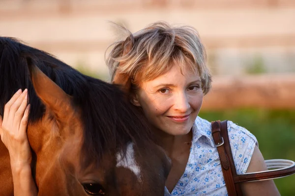 Vrouw omhelzing bruin paard — Stockfoto