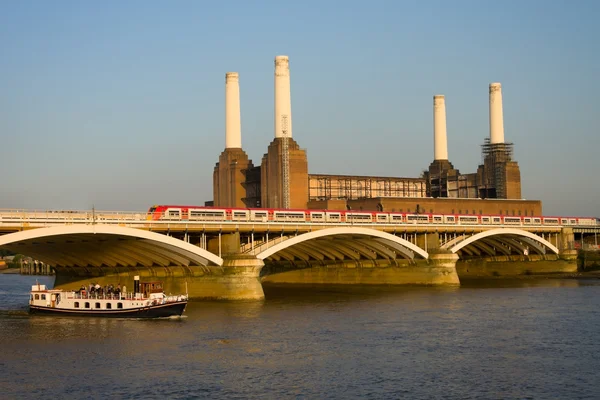 Kraftwerk mit Eisenbahnbrücke und Touristenboot — Stockfoto