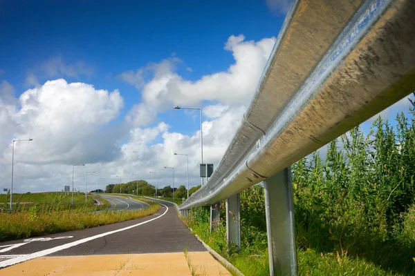 Carretera con valla lateral metálica protectora y cielo — Foto de Stock