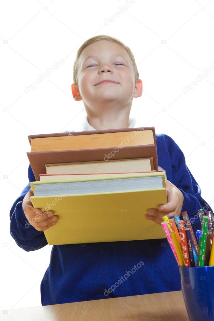 Smiling boy holding a heap of books, isolated