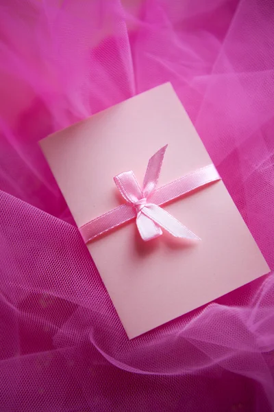 Розовый картон с атласным бантом — стоковое фото