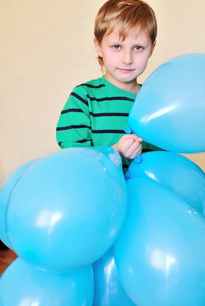 Niño sosteniendo una gran cantidad de globos — Foto de Stock