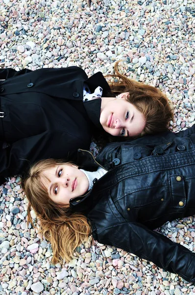 Two teen girls laying on the pebble — Stock Photo, Image