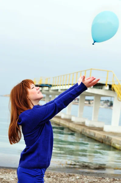 Rothaariges Mädchen schiebt Luftballon hinaus — Stockfoto