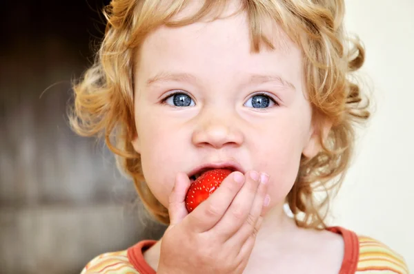 Malá holka jí jahody — Stock fotografie