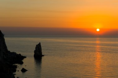 Rock ve deniz dalgaları, gün batımı