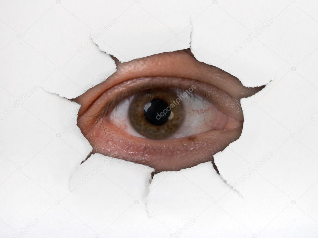 Eye looking through hole on paper