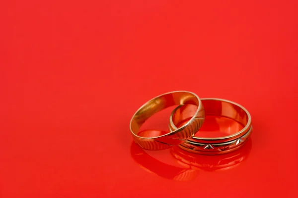 Gold wedding rings on red — Stock Photo, Image