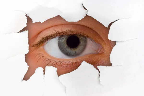 stock image Eye looking through hole on paper