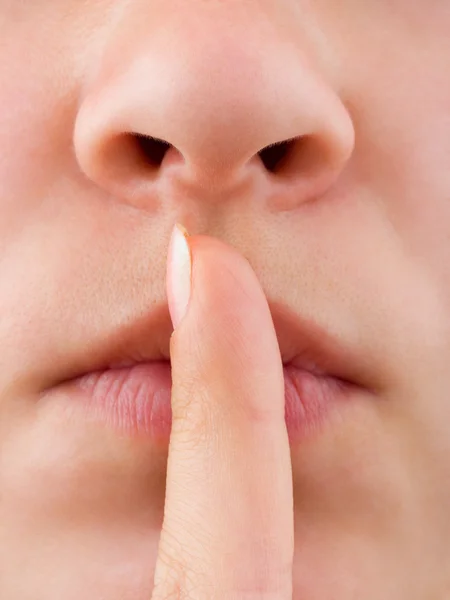 Kvinna anläggning finger till lip — Stockfoto