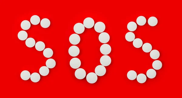 Palavra SOS feito de comprimidos — Fotografia de Stock