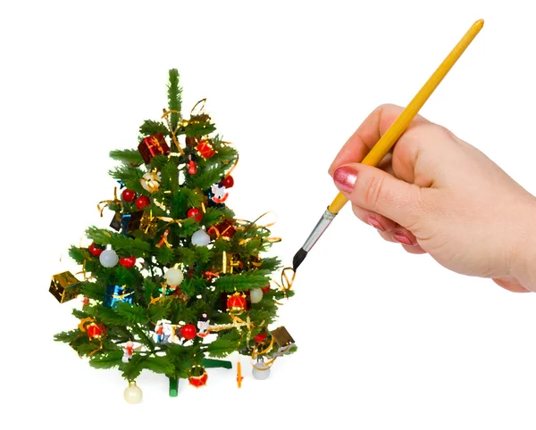 Hand with paintbrush and christmas tree — Stock Photo, Image