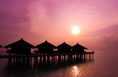 Sunset and water bungalows clipart