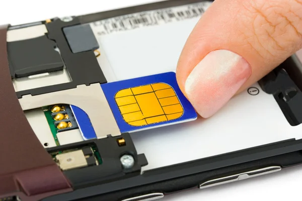 Installazione della scheda SIM a mano sul telefono cellulare — Foto Stock
