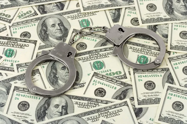 stock image Handcuffs on money background