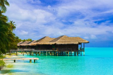 Water bungalows on a tropical island clipart