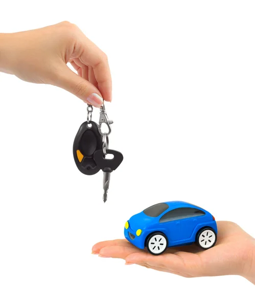 Handen met sleutels en speelgoedauto — Stockfoto