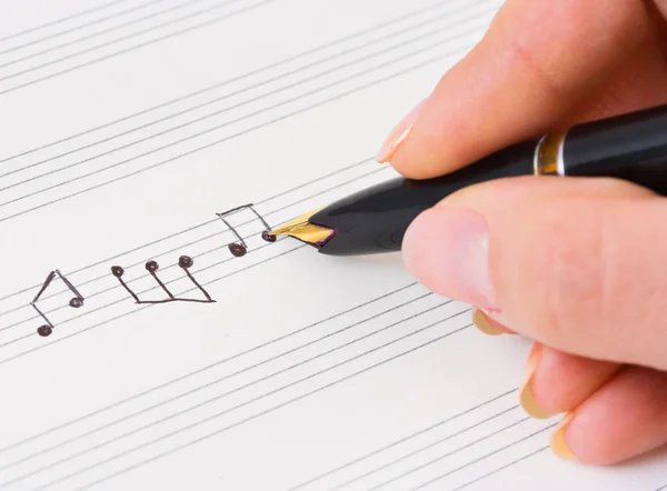Рука з ручкою і музичним аркушем — стокове фото
