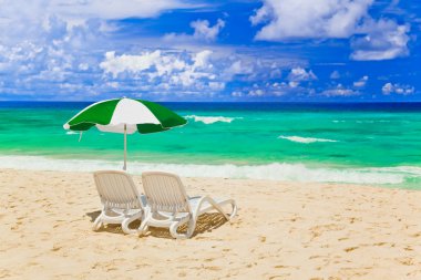 Chairs and umbrella at tropical beach clipart