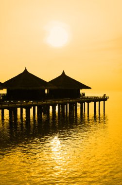 Water bungalows and sunset clipart