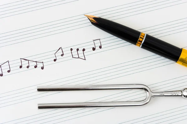 Pitchfork и ручка на нотном листе — стоковое фото