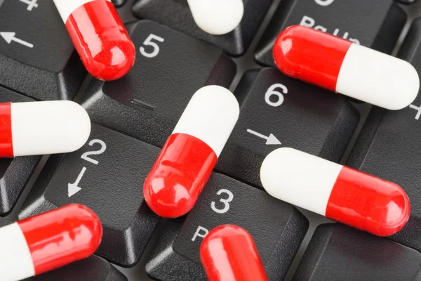 Tabletki na klawiaturze komputera — Zdjęcie stockowe