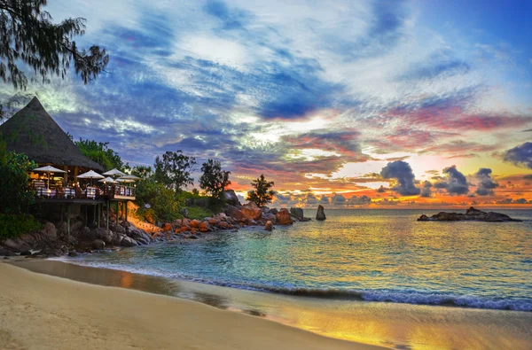在日落的热带海滩上咖啡馆 免版税图库图片