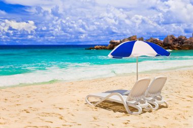 Chairs and umbrella at tropical beach clipart