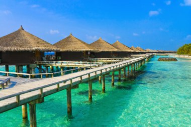 Water bungalows on a tropical island clipart