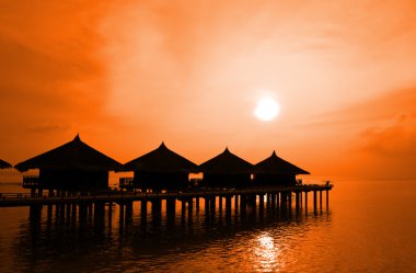 Sunset and water bungalows clipart