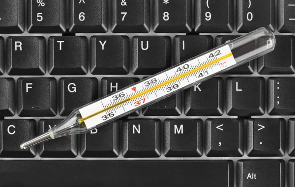 コンピューターのキーボード上の温度計 — ストック写真