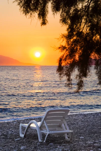 Stuhl am Strand bei Sonnenuntergang — Stockfoto