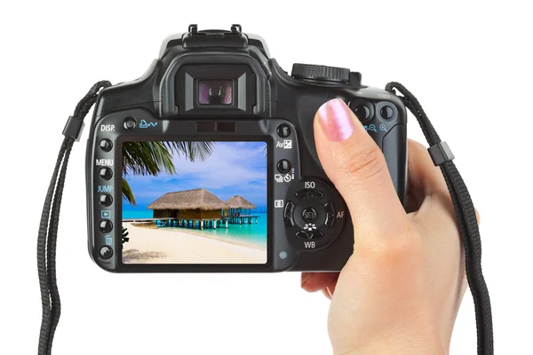 Camera in hand and beach landscape — Stock Photo, Image