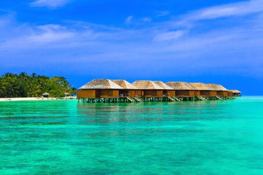 Water bungalows on a tropical island clipart