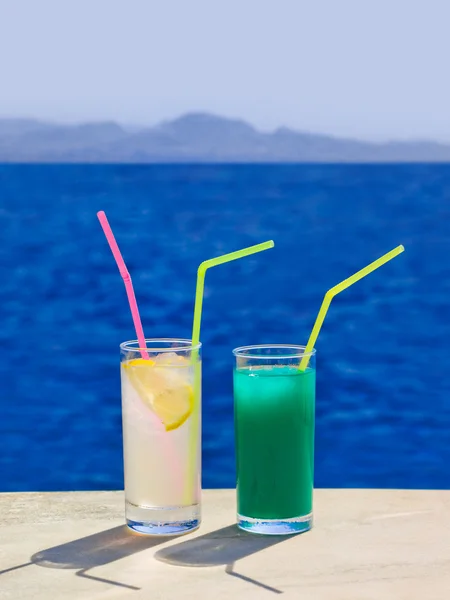 To cocktailer på marmorbord på stranden – stockfoto