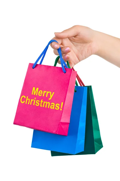 Hand met shopping tassen vrolijk kerstfeest — Stockfoto