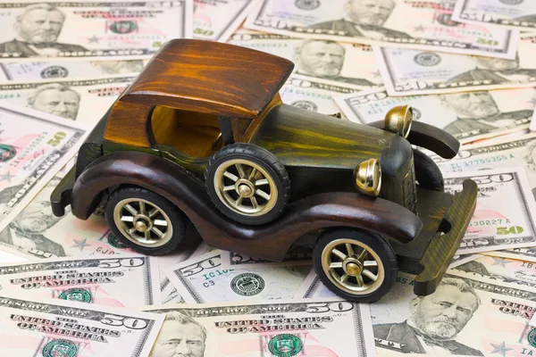 Игрушечный ретро-автомобиль на фоне денег — стоковое фото