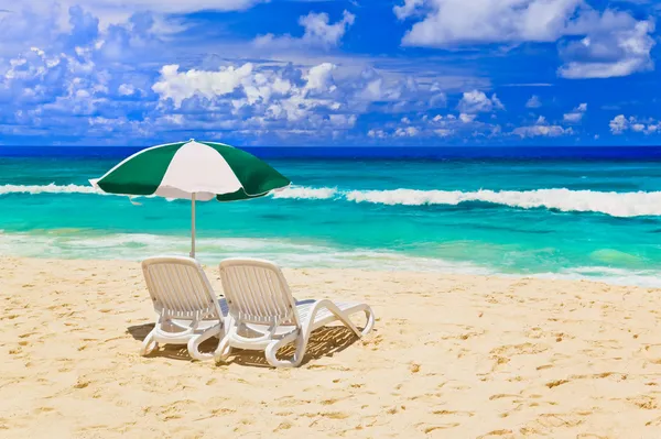 Стільці і парасолька на тропічному пляжі — стокове фото
