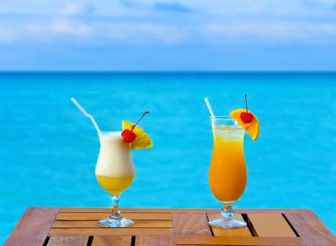 Two cocktails on table, sea background clipart