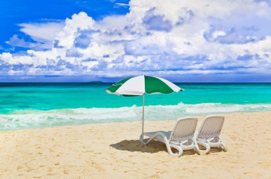 Chairs and umbrella at tropical beach clipart