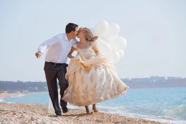 Pareja de boda corriendo en la playa — Foto de Stock