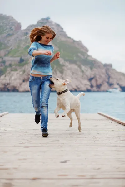 Девушка с собакой бегает — стоковое фото