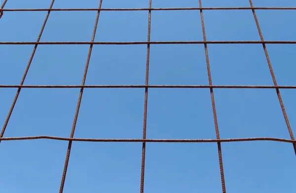 Converging view of rusty lattice on sky background — Stock Photo, Image