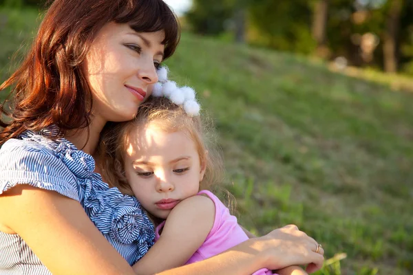 Mother and daughter sit on the grass — Stock Photo, Image
