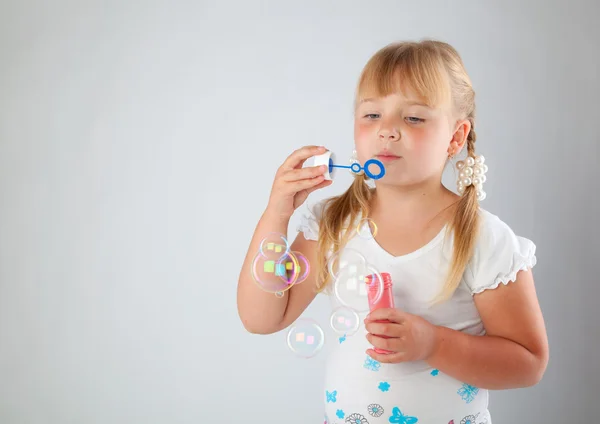 Young girl blow out soap bubbles — Stock Photo, Image