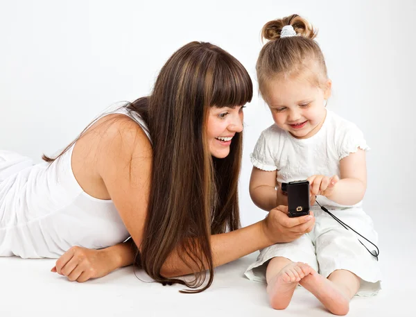Matka a malá dcera mluví po telefonu — Stock fotografie