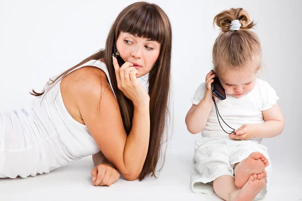 Mother and little daughter speaking by phone — Stock Photo, Image