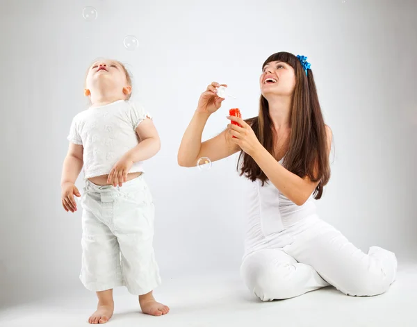 छोटी लड़की और उसकी माँ बुलबुले उड़ा रही है — स्टॉक फ़ोटो, इमेज