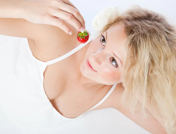 Ung kvinna i vit klänning äta jordgubbar — Stockfoto
